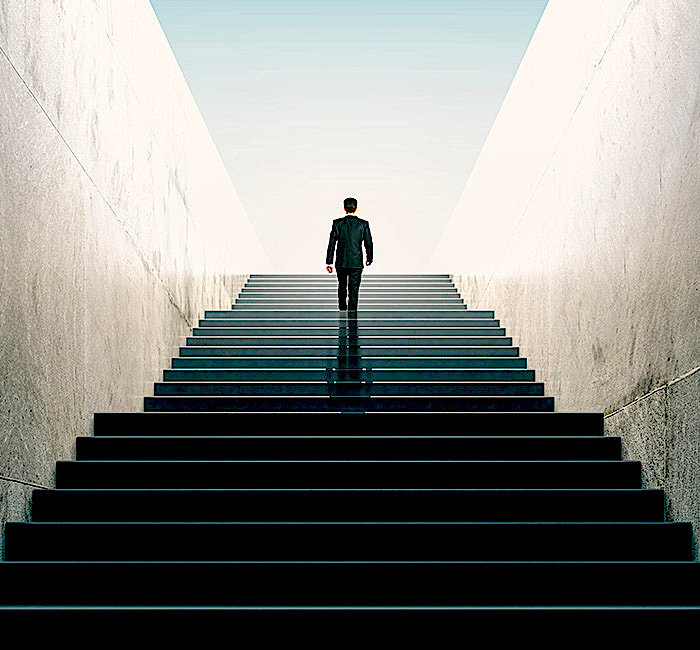 Ein Mann im Anzug steigt eine Treppe rauf
